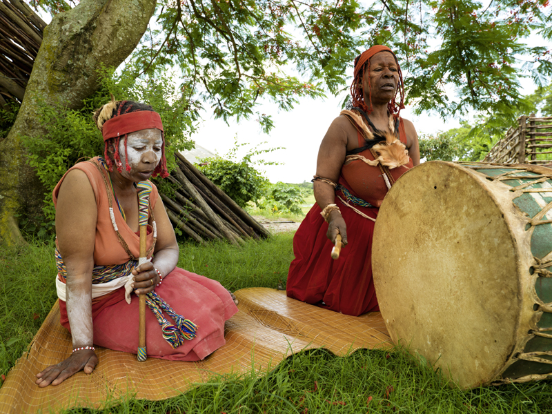 Two Sangomas sitting in gras and playing music.